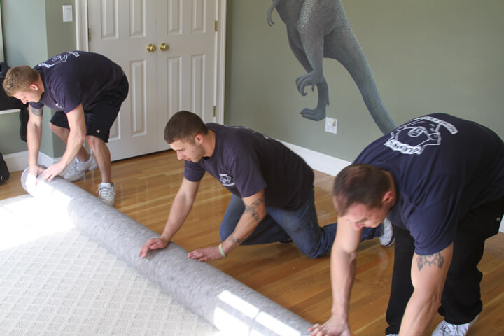 movers wrapping a carpet