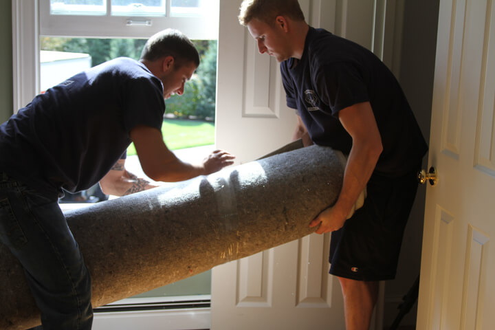 Movers moving a rug