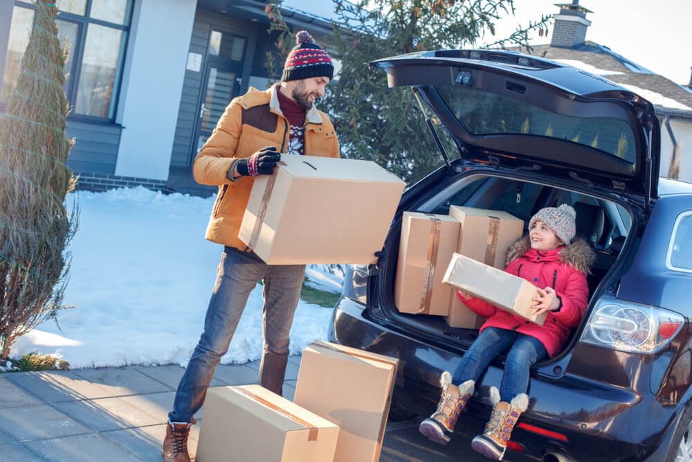 father and daughter moving boxes out of a car